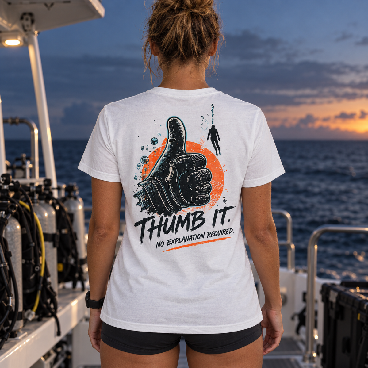 Thumb It. white tee back with a black scuba glove, oxidized orange circle, teal bubbles, and No Explanation Required lettering on a dive boat.